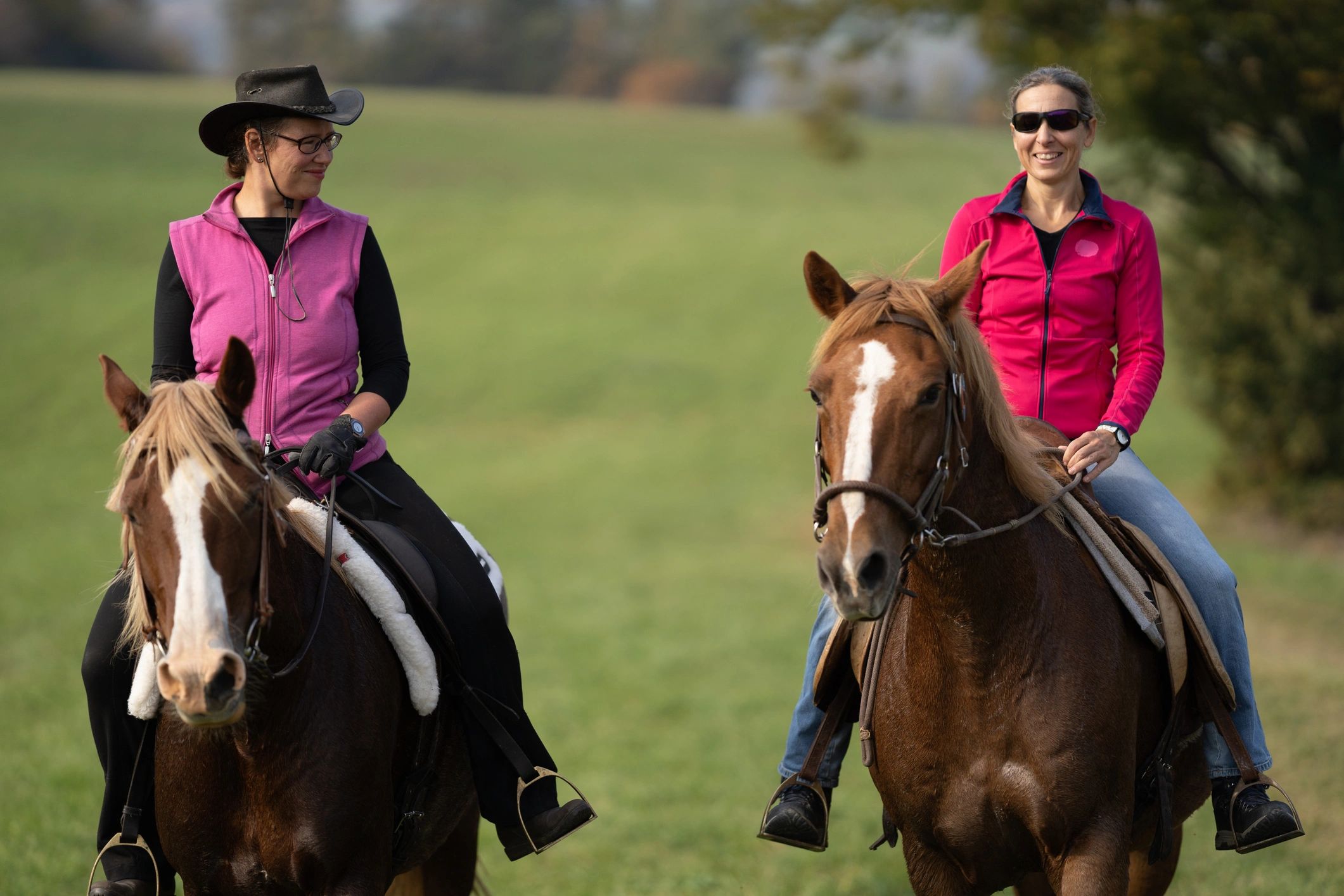 Women enjoying a guided horseback ride outdoors